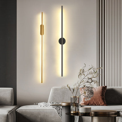 Modern wall sconce in a living room setting with a gray sofa and decorative elements.