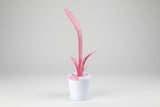 Pink and white cleaning brush with a cylindrical holder on a white background