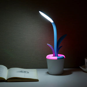 Three LED desk lamps with plant designs on a dark background